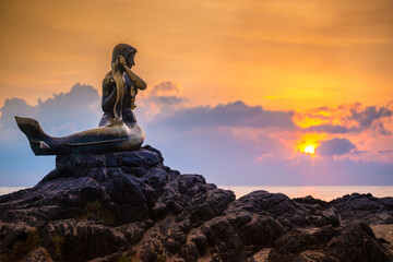 Golden mermaid statue at sunrise at the Samila beach, Songkhla, Thailand.