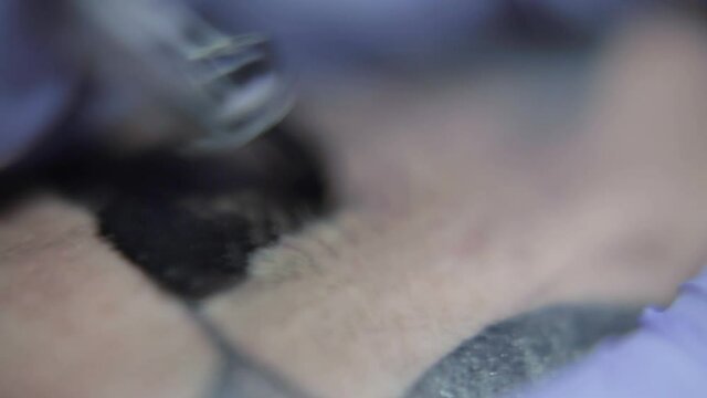 Maquina de tatuar rellenando un tatuaje