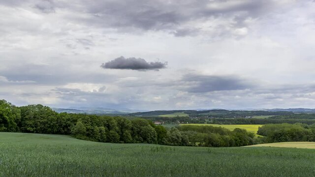 Timelapse view of a hilly landscape with a field and a fresh crop of dark clouds moving in the sky overlooking the surrounding hilly landscape Hranice na Morave Czech Republic