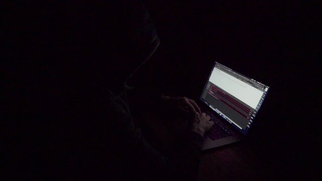 Hacker concept using a computer with stong lighting and dramatic impression