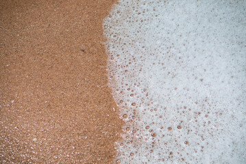 Sand and sea foam view from above