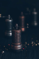 Pepper or coffee vintage metal grinder on a dark black background