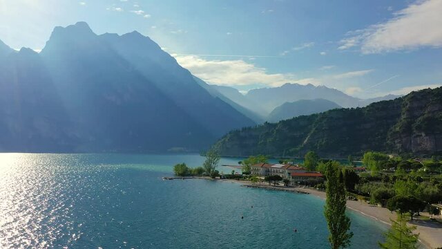 Aerial video with drone, view of the Torbole a small town on Lake Garda, Italy. Europa.beautiful Lake Garda surrounded by mountains in the summer time