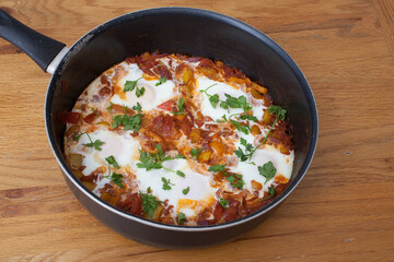 An Egyptian Shakshuka dish with eggs poached in a tomato and bell pepper sauce