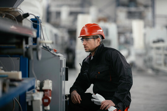Factory worker. Man working on the cables and wires.