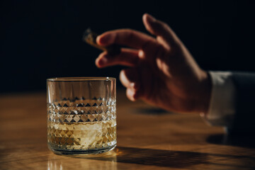 Close up of hands of man drinking whisky.	