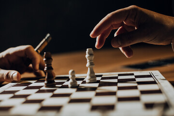 Close up of hands of men playing chess.	
