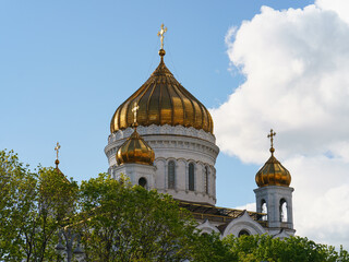 Fototapeta na wymiar Photography of the Domes of the Cathedral of Christ the Saviour. Blue spring sky with white fluffy clouds. Coronavirus pandemic time.