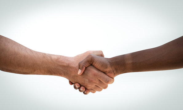 Handshake between african and a caucasian on white background.Interracial handshake on isolated background.