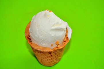 photo of a cup of vanilla ice cream on a green background