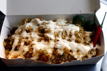Filipino delicacy called Sisig topped with chicharon and mayonnaise