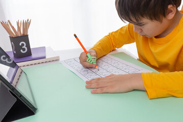 child do homework, boy use ergonomic training pencil holder, correcting pencil grip, teaching...