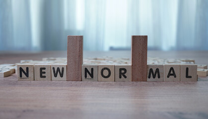 new normal , alphabets wooden cubes, wooden background table, view from above.