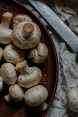 fresh champignon mushrooms on a clay plate