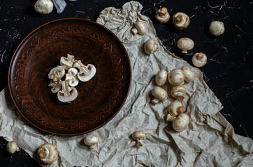 fresh champignon mushrooms on a clay plate