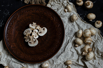 Fototapeta na wymiar fresh champignon mushrooms on a clay plate