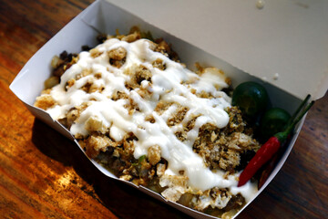 Filipino delicacy called Sisig topped with chicharon and mayonnaise