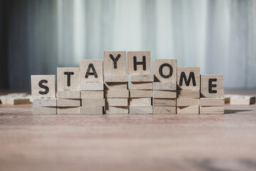 stay home, alphabets wooden cubes, wooden background table, view from above.