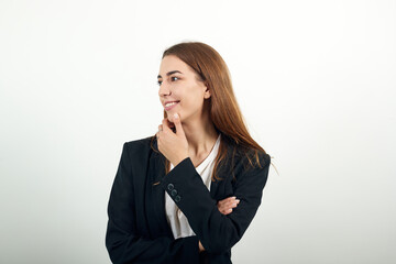 Hand on chin thinking about question, pensive expression. Doubt. Thoughtful face. Using that incredibly sharp business mind. Young attractive woman with brown hair in a light t-shirt and black jacket