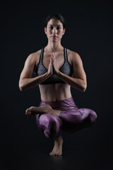Fototapeta na wymiar Woman doing yoga in dark background