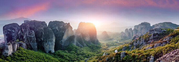 Wonderful Panoramic view of the rocks and monasteries of Meteora, Greece. Mysterious Sunny Morning during sunrise. Awesome Nature Landscape. Amazing Greece. Popular travel locations.
