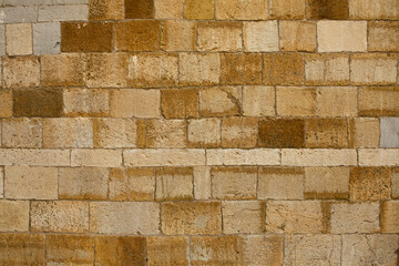 Ancient brick stone wall. Light brickwork of bricks of different sizes ocher color. Abstract...