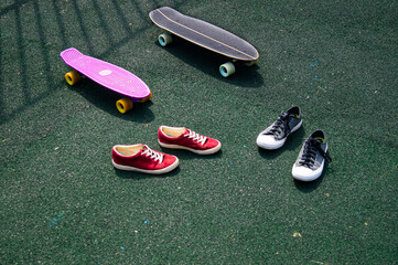 red sneakers and gray sneakers and skateboards on the sports ground