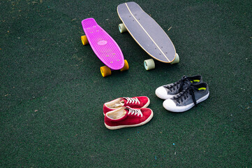 red sneakers and gray sneakers and skateboards on the sports ground - Powered by Adobe