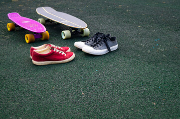 red sneakers and gray sneakers and skateboards on the sports ground