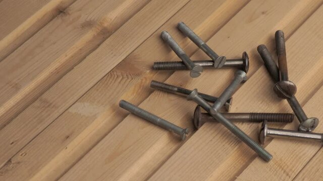 old iron bolts on a corrugated wooden Board. smooth rotation
