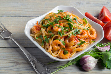 spaghetti with prawns in tomato sauce with herbs.