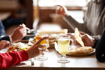Hands view of young people eating brunch in trendy bar restaurant - Healthy lifestyle, food trends concept - Focus on left woman hand, dish