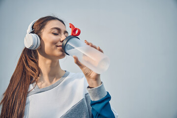 Sportive Caucasian lady restoring her water balance
