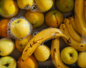 Photograph of a set of fruits that are being washed