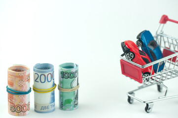 Russian money in a shopping cart and with a car, the concept of buying a car