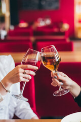 Girlfriends drinking wine while sitting in the restaurant after quarantine is over. Hands only