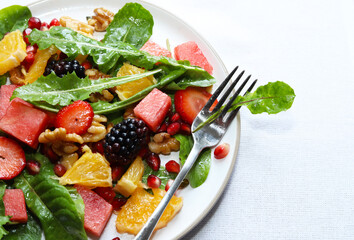 Colourful dandelion salad with fresh fruit.