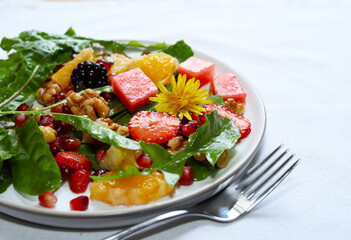 Colourful dandelion salad with fresh fruit.