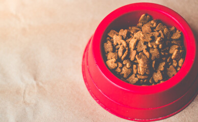 Dry cat food in bowl on craft background. Top View