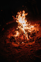 glowing warm campfire at night.
Bonfire. Orange flame of a fire. Bonfire on the grill with smoke.  Bonfire close. Fire in nature. Bonfire background.