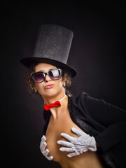 Beautiful emotional woman or girl in a black hat and a tailcoat and white gloves, in the image of a...