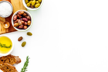 Set of green and res olives with oil on kitchen table. Top view 