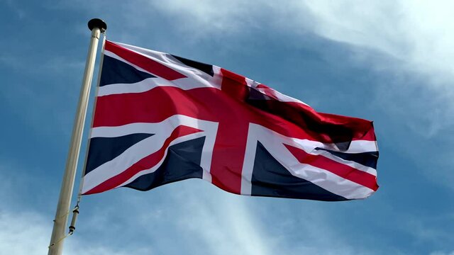 British flag. Union Jack is the national flag of the United Kingdom of Great Britain and Northern Ireland. Flying on a flag pole
