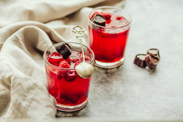 Close-up on glass cup berry fruit jelly pudding with fresh raspberries - summer dessert  in glasses on gray background. Diet dessert concept