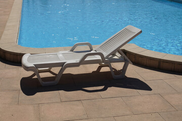 
white plastic deck chair by the pool
