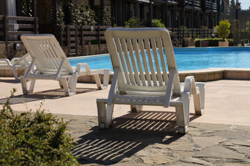 
white plastic deck chair by the pool