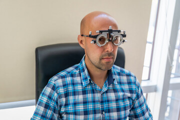 vision measurement by optometrist at clinic, young man as patient