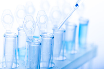 microbiological pipette in the genetic laboratory. study of a virus or vaccination. blue tinted.