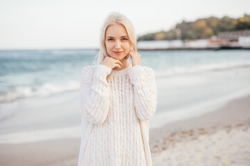 Attractive young woman on sand ocean shore in cloudy day