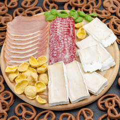 Cheese, ham, cereal on a cutting board. Curly brown cookies